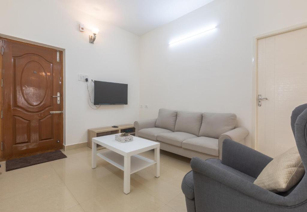una sala de estar con un sofá y una mesa en Cozy Nook 3BHK Virugambakkam, en Chennai