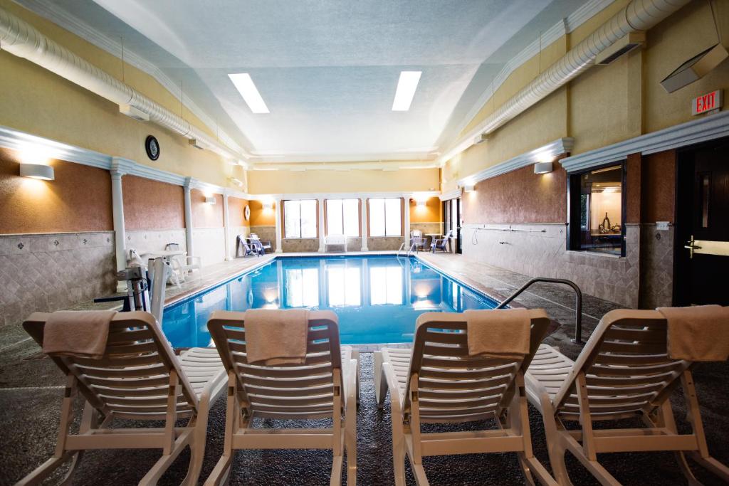a pool with chairs and chairs around it at Days Inn by Wyndham Minot in Minot