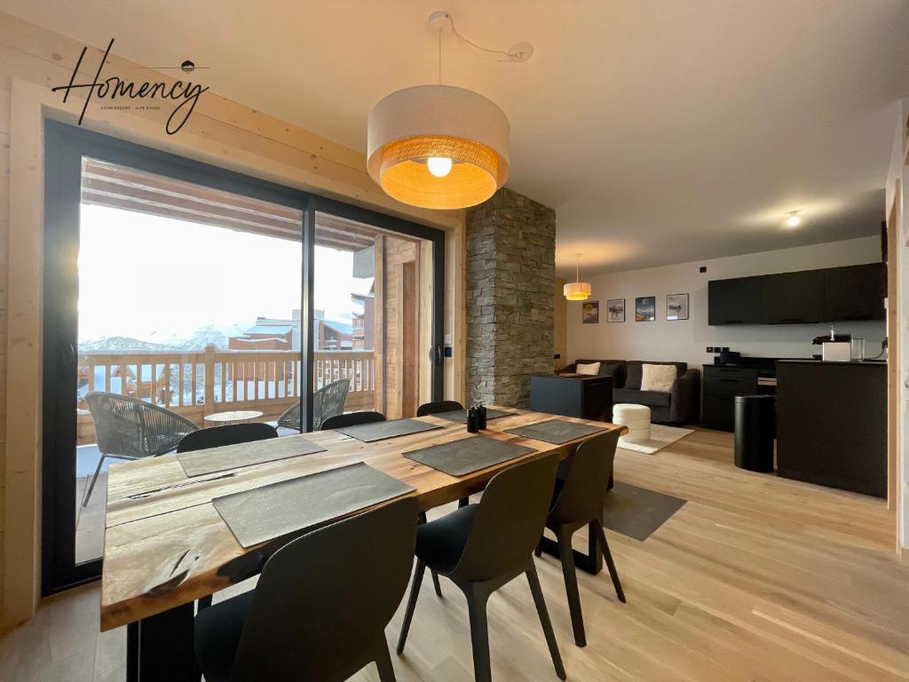 une salle à manger avec une table et des chaises et un salon dans l'établissement Homency - Résidence Chalets du Golf - Albatros A203, à L'Alpe-d'Huez