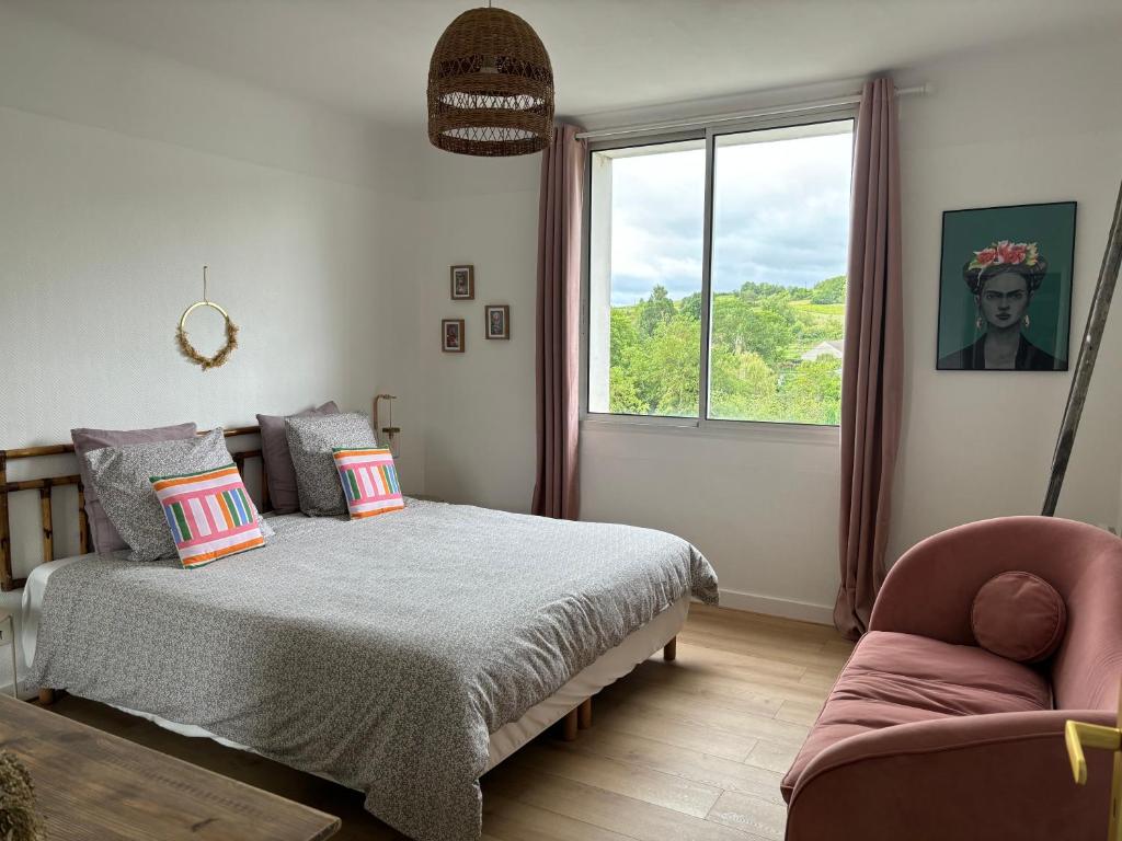 una camera da letto con un letto, una finestra e una sedia di La terrasse de Sancerre a Saint-Satur