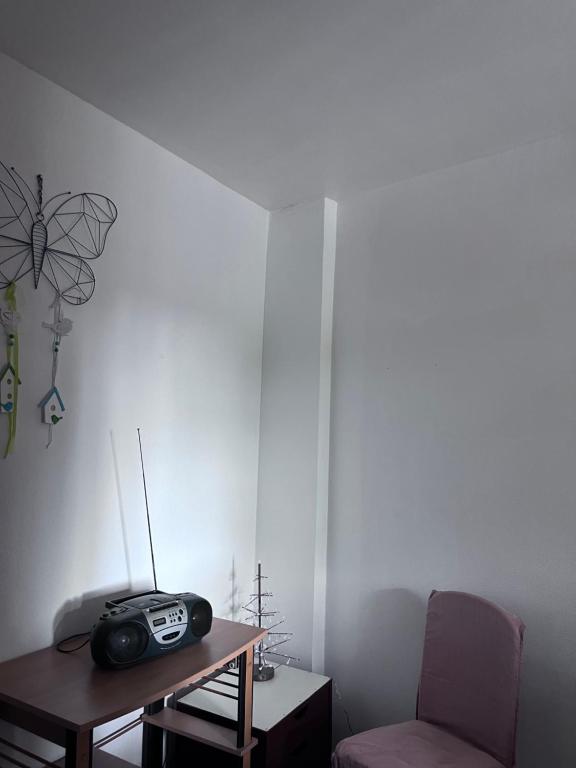 une chambre avec une table, une radio et une chaise dans l'établissement Studio lumineux, à Corbeil-Essonnes