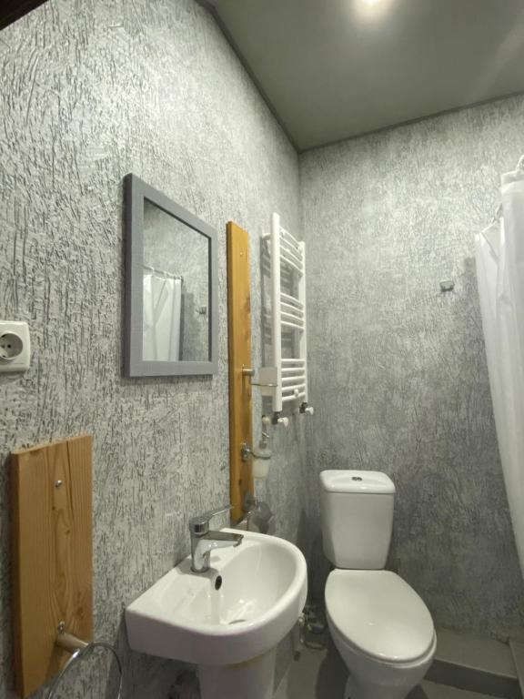 a bathroom with a white toilet and a sink at Hotel Cité in Mtskheta