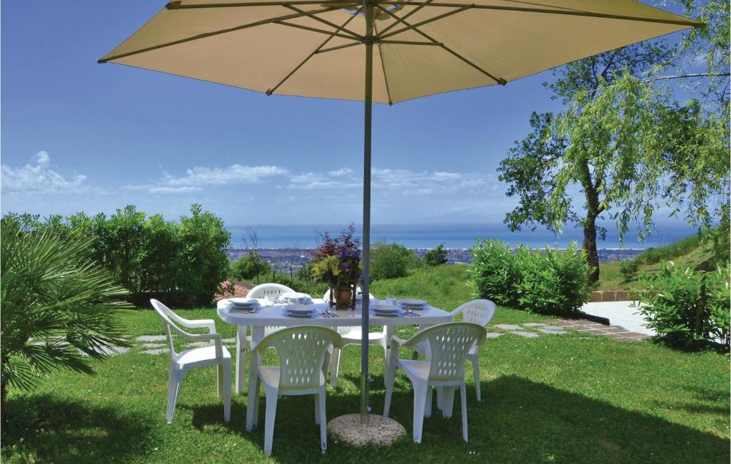 a table with an umbrella in the grass at Villa 1 in Corsanico-Bargecchia