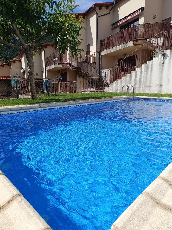 a large blue swimming pool in front of a building at EL BALCÓN PANORÁMICO DEL TIÉTAR in Mijares