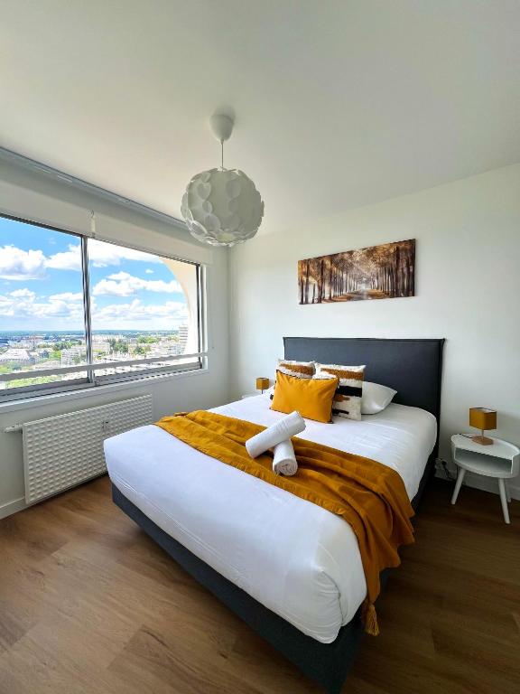 une chambre avec un grand lit avec une grande fenêtre dans l'établissement L Horizon, Rennes centre, à Rennes