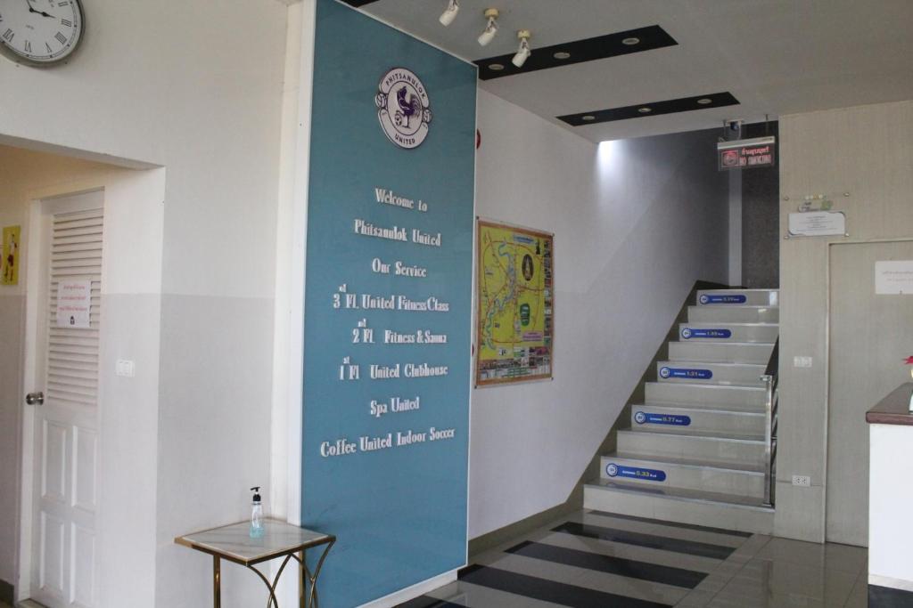 a stairway with a blue wall with writing on it at Phitsanulok United in Phitsanulok