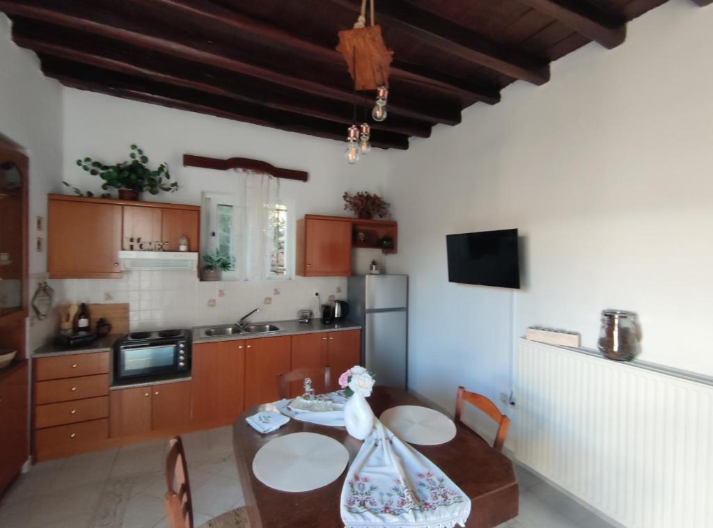 Una cocina con una mesa con sillas y un refrigerador. en casa mouliana, en Éxo Moulianá