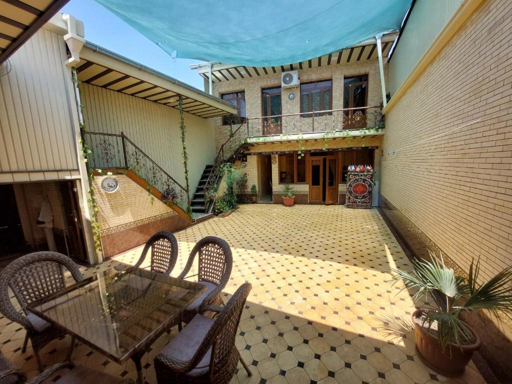 an empty patio with chairs and a table in front of a building at Family guest house SEVEN in Samarkand