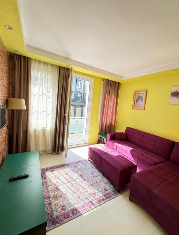 a living room with a purple couch and a table at Plaesant apartment with Balcony in Istanbul