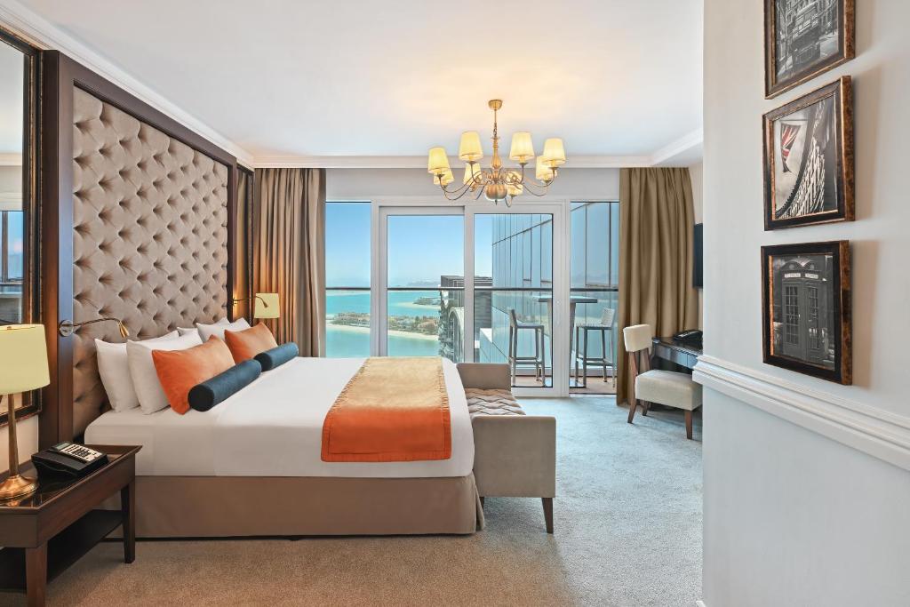 a bedroom with a king sized bed and a living room at Dukes The Palm Dubai Hotel in Dubai