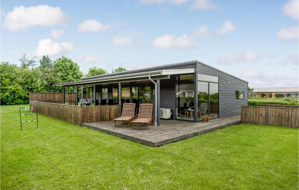 a tiny house with a deck in a yard at Holiday Home Ellemose in Skovby
