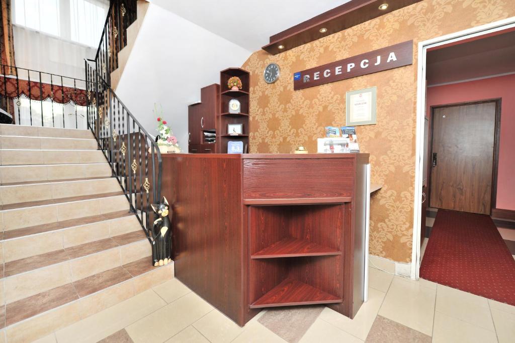 a lobby with a staircase and a wooden counter at Pensjonat Stańczyk in Krakow