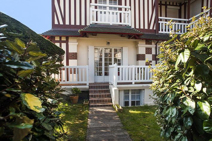 Cette petite maison dispose d'une terrasse couverte et d'une balustrade blanche. dans l'établissement Petit Souplex dans l'hypercentre de Cabourg 80 m de la mer à pied, à Cabourg