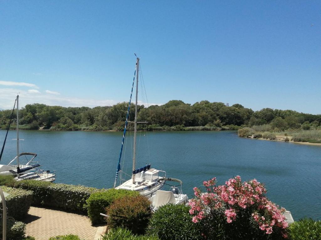 un bateau est amarré sur une rivière fleurie dans l'établissement VUE LAGUNE ET BATEAUX A 100M DE LA PLAGE, à Saint-Cyprien
