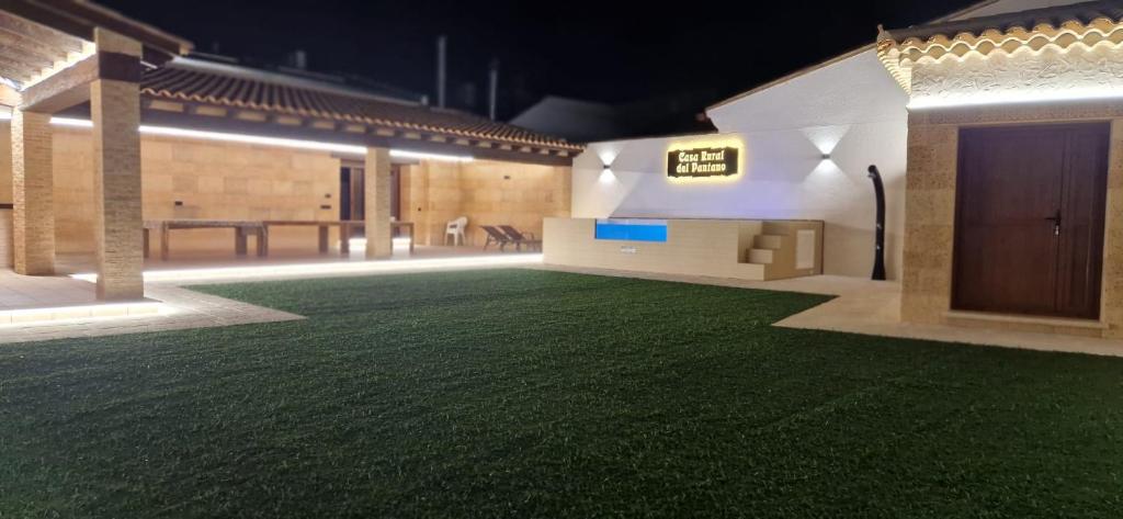 una grande stanza con un prato verde al centro di Casa Rural del Pantano 4 Estrellas a Buenache de Alarcón