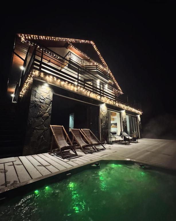 a house with a swimming pool at night at Willa Krzyżówki obok Korbielowa in Krzyżówki