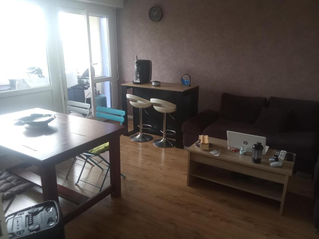 un salon avec un canapé et une table dans l'établissement Appartement bien situé, à Bourg-en-Bresse