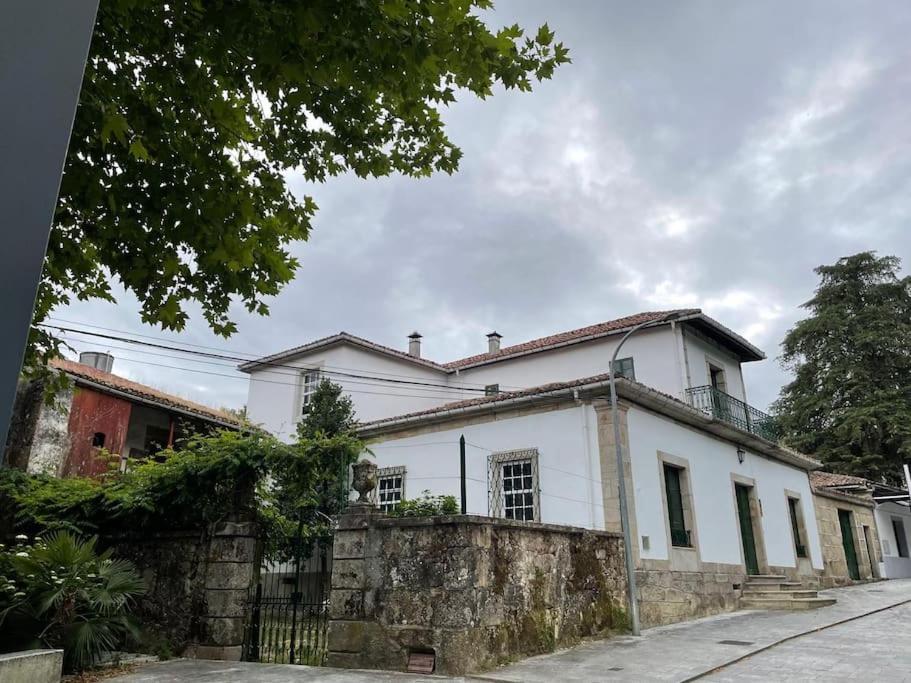 a white house with a stone wall at La casa de Entrimo in Entrimo