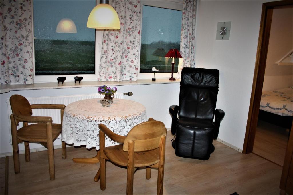 ein Esszimmer mit einem Tisch und zwei Stühlen und einem Tisch und einem Stuhl in der Unterkunft Haus Halligblick, Ferienwohnungen am Wattenmeer, Whg Gröde in Dagebüll