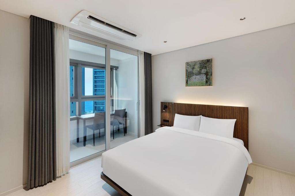 Postel nebo postele na pokoji v ubytování NewCZ Haeundae Residence