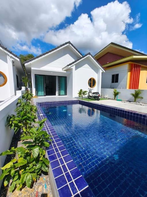 a swimming pool in front of a house at Waan Samui Pool Villa in Taling Ngam Beach
