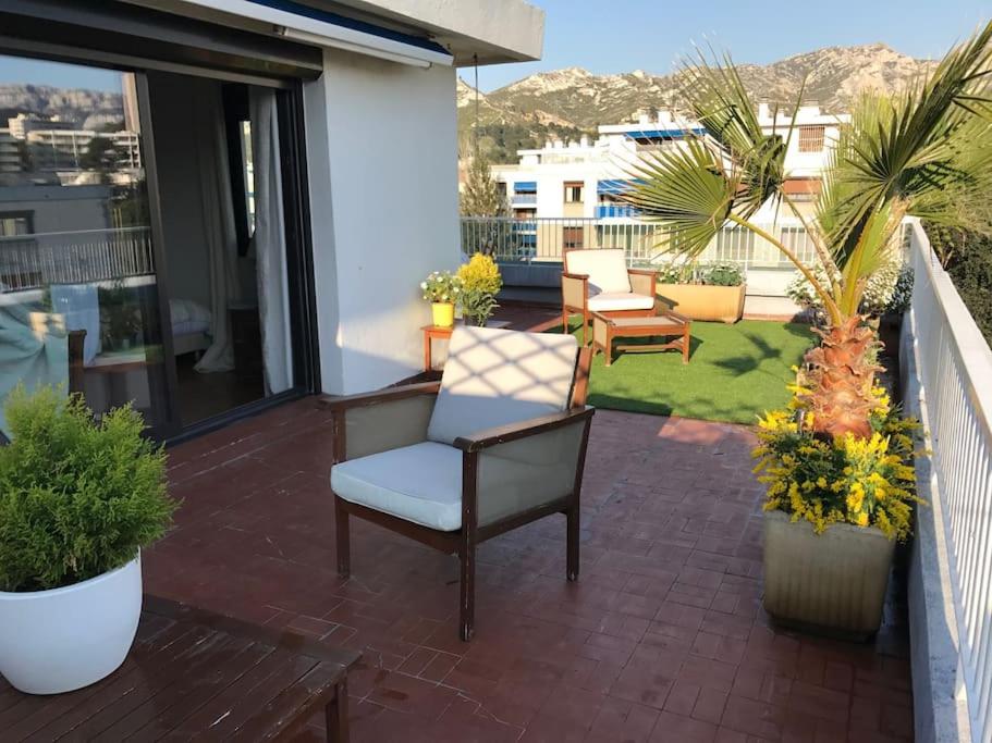 d'une terrasse avec des chaises et des plantes sur un balcon. dans l'établissement Apt proche des Calanques, à Marseille