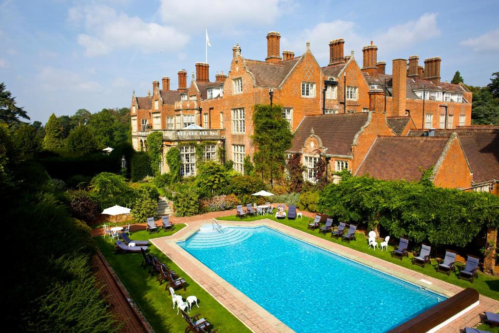 a large house with a swimming pool in front of it at Tylney Hall Hotel in Hook
