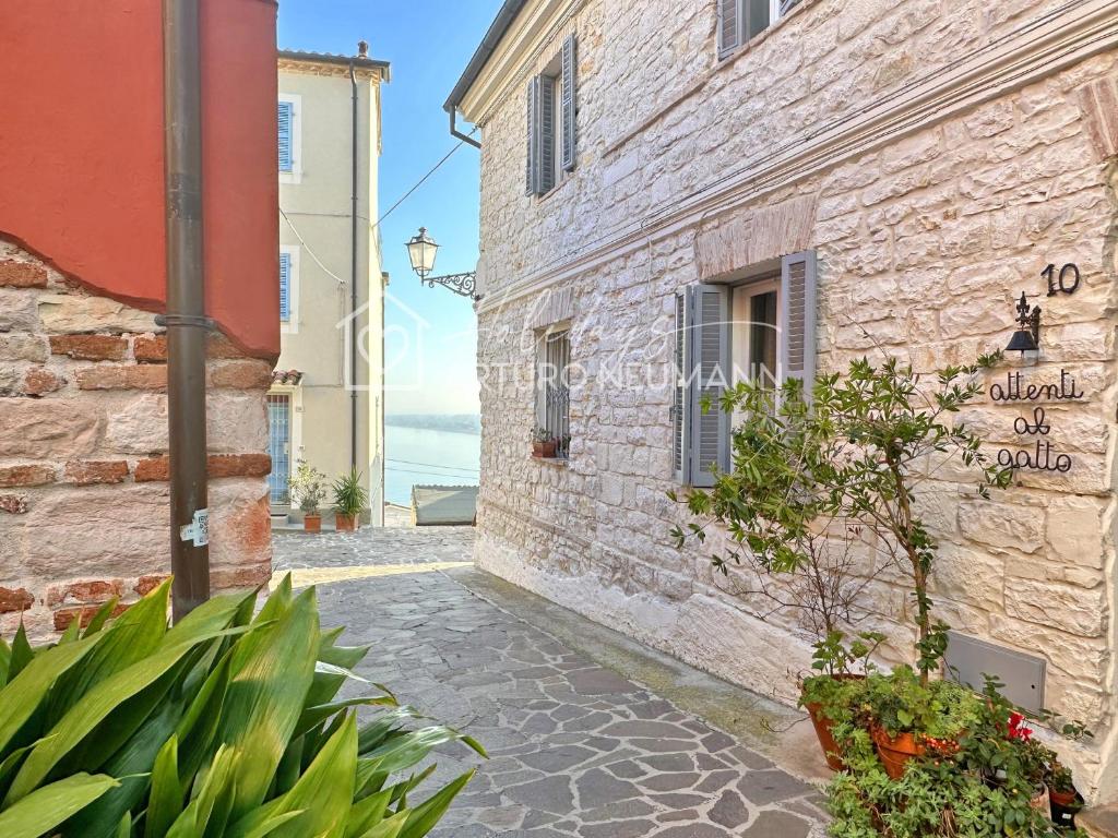 a street in a stone building with plants and flowers at 124 - Deliziosa casa cielo-terra a Numana in centro storico, con splendida vista sul mare - SPIAGGIA WHITE BEACH CLUB OMAGGIO dal lun al ven FINO AL 02-08 in Numana