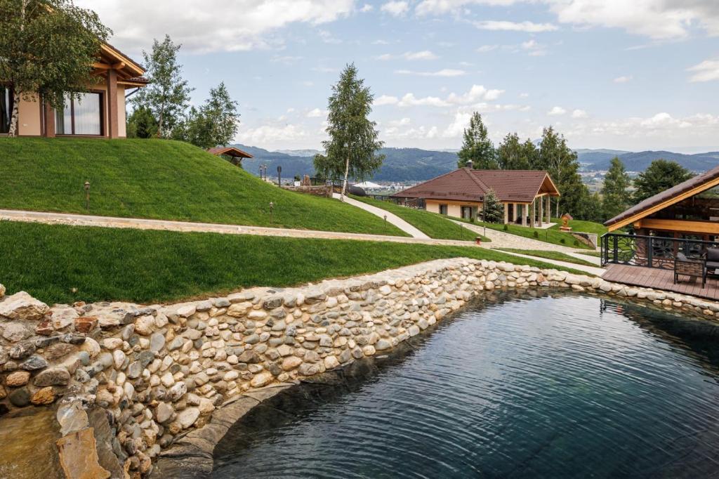 una pared de piedra junto a una piscina de agua en Vista Valley Resort, en Zărneşti