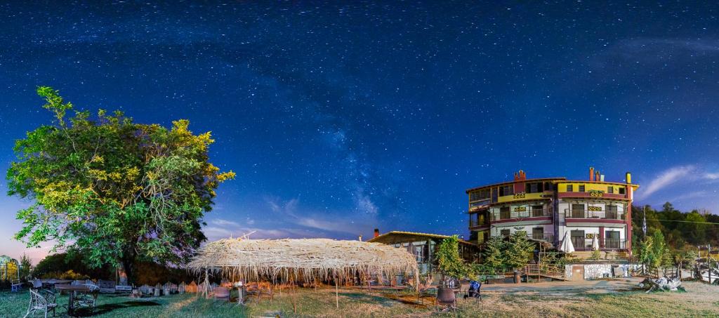 un edificio bajo un cielo estrellado con gente a su alrededor en Mouson Melathron, en Elafina