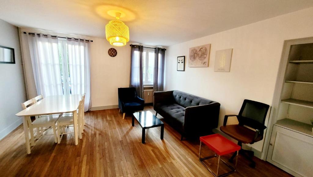 ボーヴェにあるAppartement meublé Hypercentre Beauvais - 1h de Parisの黒いソファとテーブルのあるリビングルーム