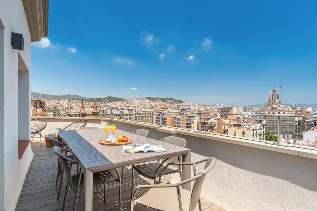 Ein Tisch und Stühle auf einem Balkon mit Aussicht in der Unterkunft The Corner Apartments by Aspasios in Barcelona