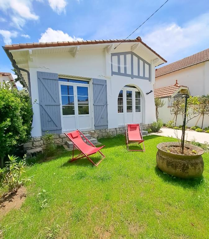 Deux chaises rouges dans la cour d'une maison dans l'établissement Mariella - MAISON FAMILIALE, WIFI, 500m de la plage, à Royan