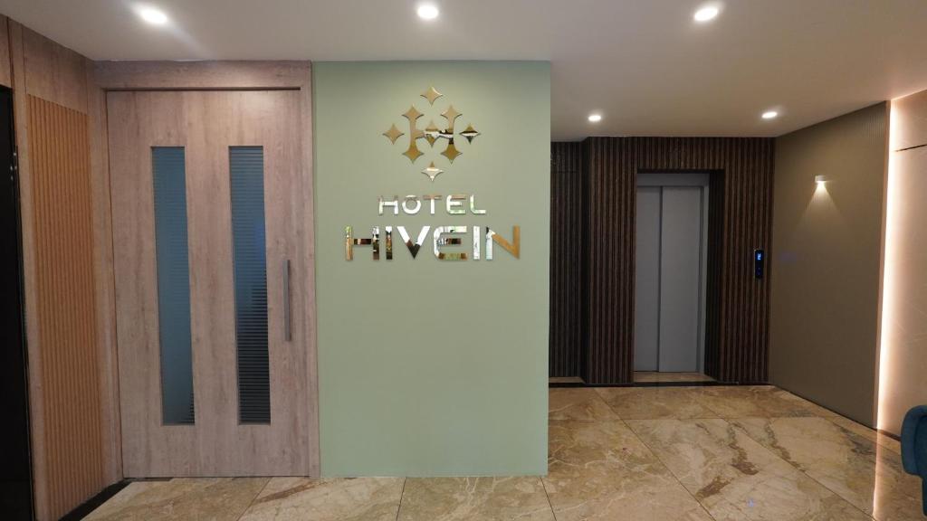 a hotel lobby with a sign on the wall at Hotel Hive Inn - Kozhikode in Kozhikode