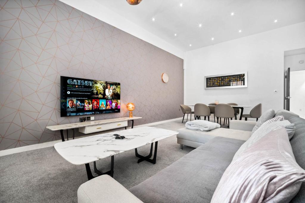 Hotel Apartment - Secure Parking - Gated Development - Near JQ & Birmingham City Centre - Top Rated - Flower Wall - 12SH, a living room with a couch and a tv at Apartment - Secure Parking - Gated Development - Near JQ & Birmingham City Centre - Top Rated - Flower Wall - 12SH in Birmingham