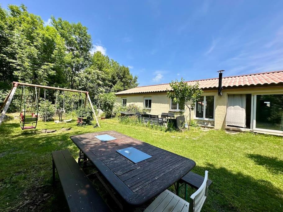- une table de pique-nique dans une cour avec une balançoire dans l'établissement Grande maison en Cévennes,montagne, lacs, rivières, à Concoules