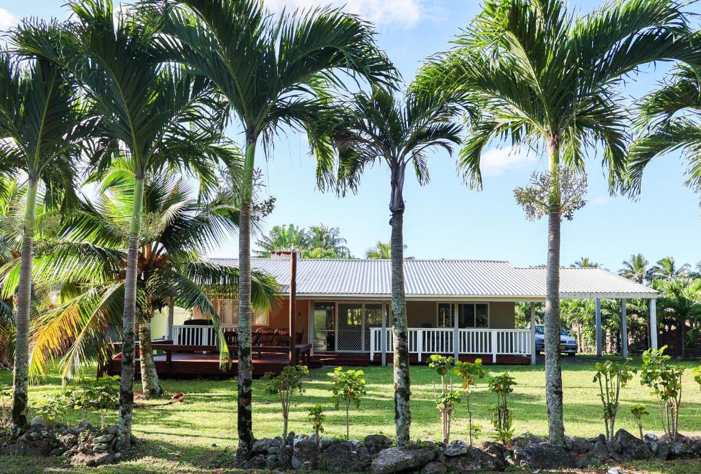 una casa con delle palme davanti di Inave Holidays a Rarotonga