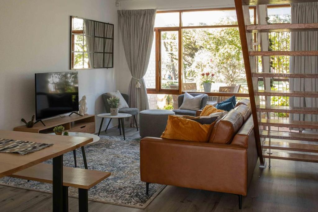 a living room with a couch and a tv at Your own space in the leafy Cape in Cape Town