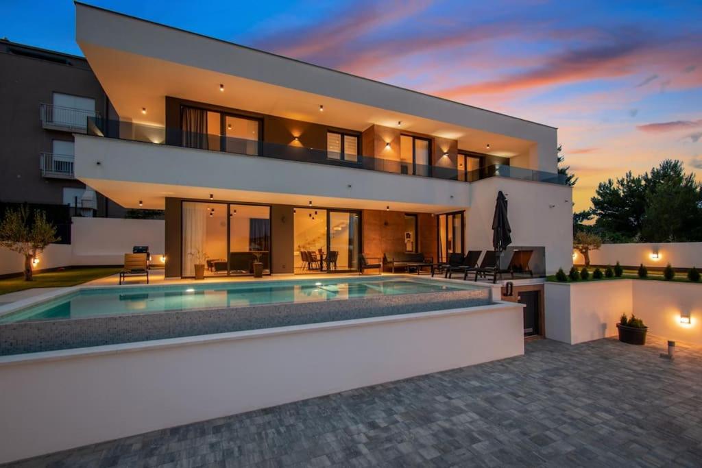 a large house with a swimming pool in front of it at Villa Infinity Gem mit beheizbarem Pool in Medulin, Istrien in Medulin