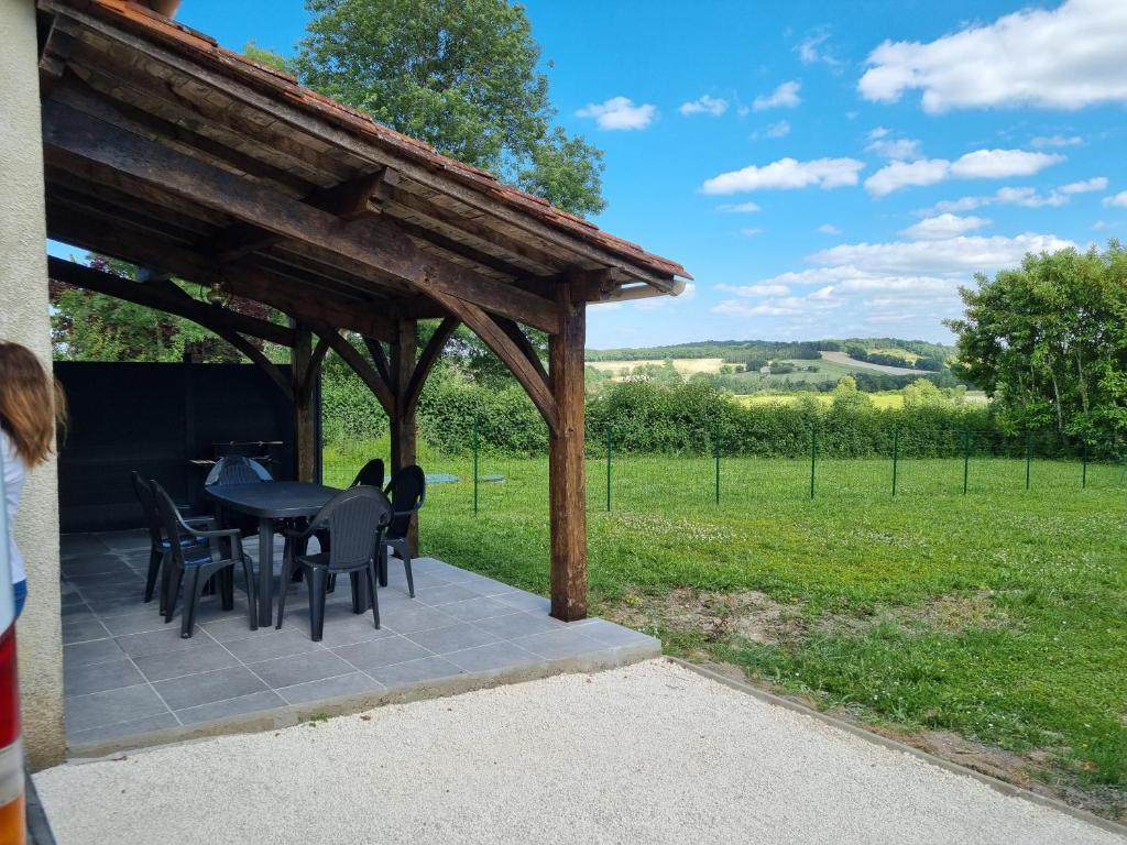 a patio with a black table and black chairs at au Bonhomme de Chemin in Saint-Martin-de-Ribérac