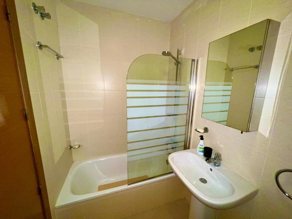 a bathroom with a sink and a tub and a mirror at Condado de Alhama PENTHOUSE 1SV32 in El Romero