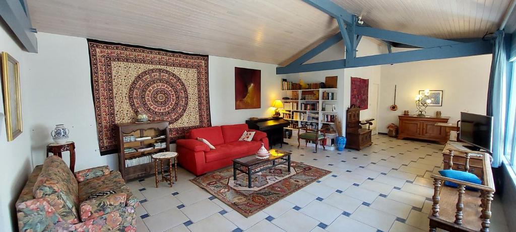 - un salon avec un canapé rouge et un tapis dans l'établissement SABLE BLEU, maison d'architecte, à Andernos-les-Bains
