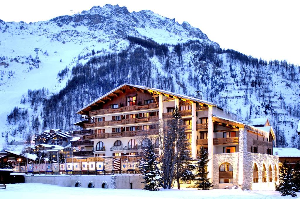 a hotel in front of a mountain with snow at Hôtel Christiania in Val-d'Isère