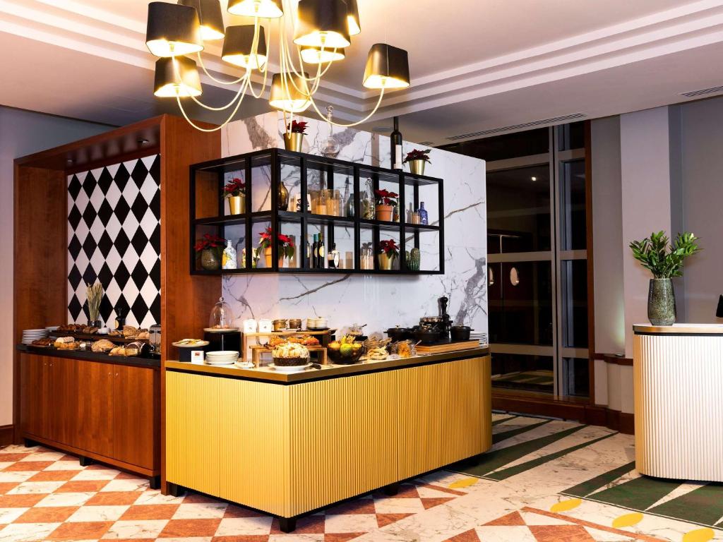 a restaurant with a yellow counter with food on it at Sofitel Luxembourg Europe in Luxembourg