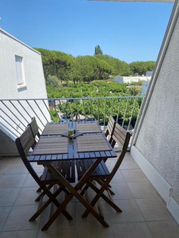 une table et des chaises en bois sur un balcon dans l'établissement La Grande-Motte Appt 4 personnes terrasse et parking privé, à La Grande Motte