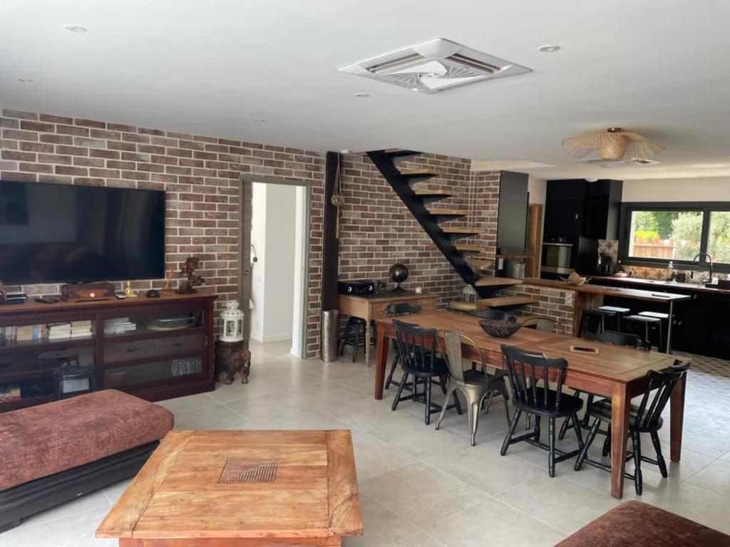 - un salon avec une table et un mur en briques dans l'établissement Petit paradis, à Soustons