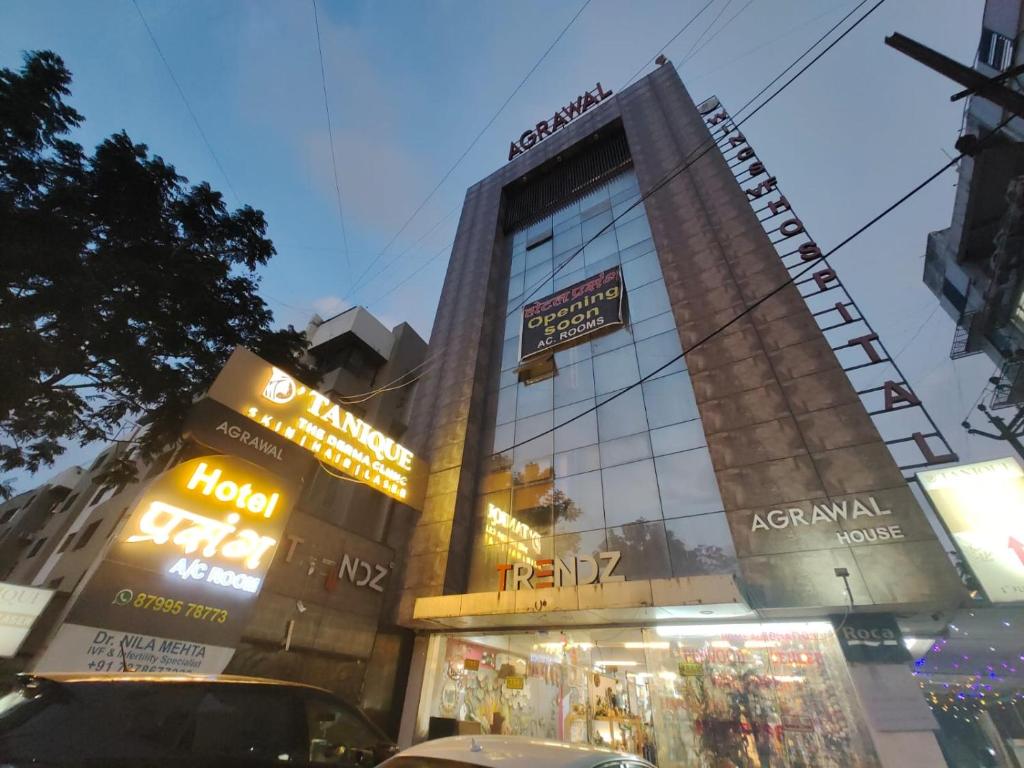 a tall building with signs on the side of it at Hotel PRASANG in Surat