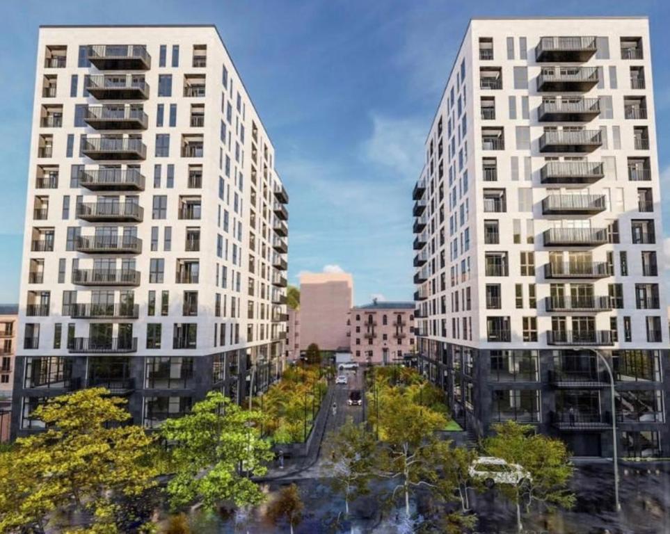 dos altos edificios blancos en una ciudad con árboles en New House, en Kapan