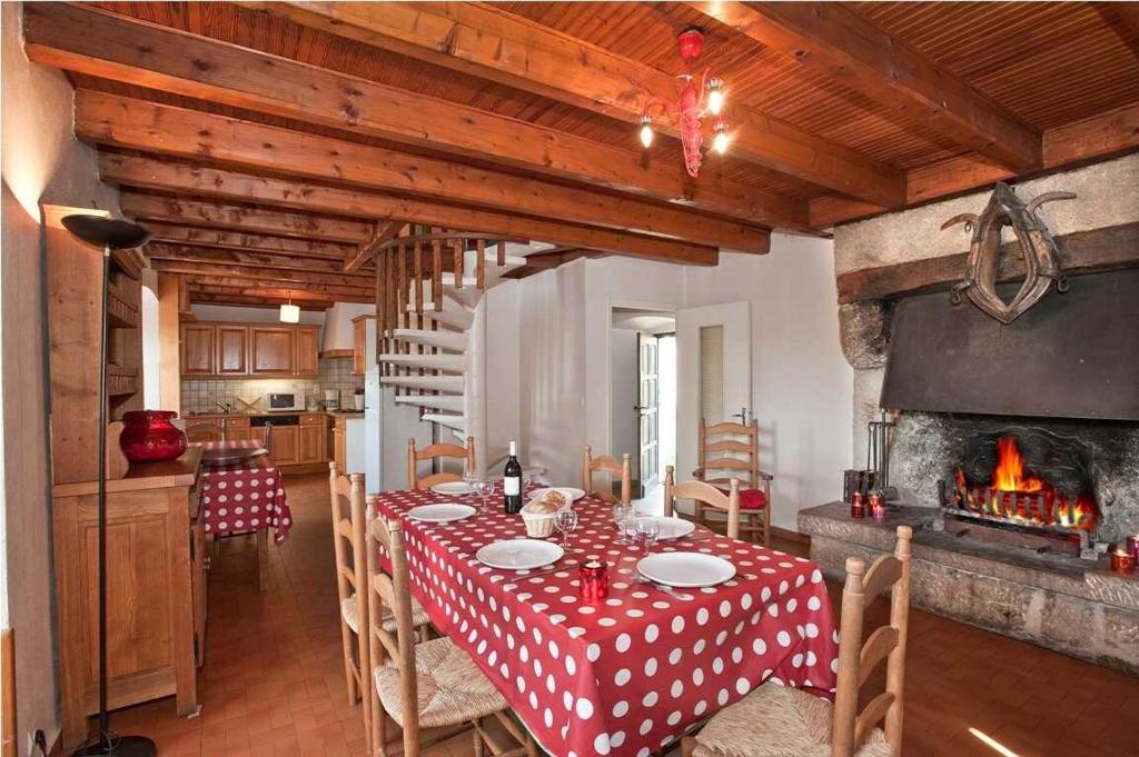 a dining room with a table and a fireplace at Gites de france 3 epis 8 personnes a conques les genevriers in La Canourgue