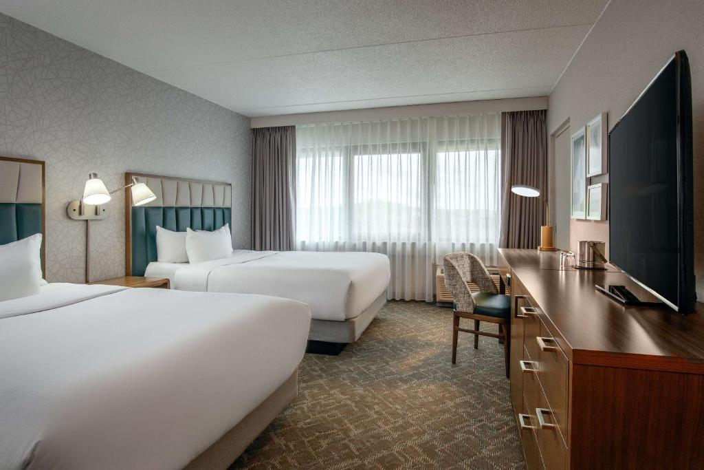 a hotel room with two beds and a desk at DoubleTree by Hilton Boston/Westborough in Westborough
